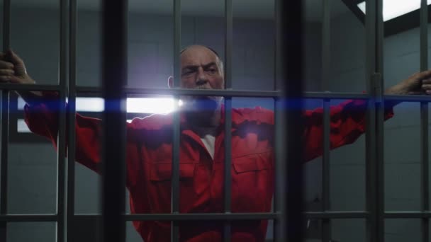 Starší Vězeň Oranžové Uniformě Drží Vězení Kovové Mříže Ruce Vinný — Stock video