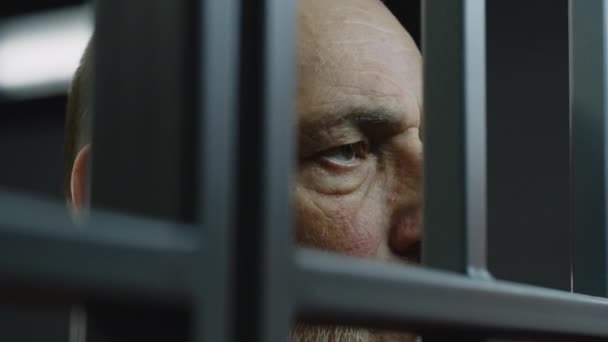Hapishane Hücresinde Metal Parmaklıkların Arkasında Duran Depresif Yaşlı Mahkumun Yüzüne — Stok video