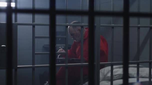 Turuncu Üniformalı Yaşlı Mahkum Hapishane Hücresinde Oturup Yemek Yiyor Suçlu — Stok video