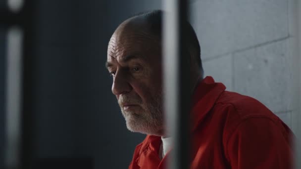 Elderly Criminal Orange Uniform Sits Prison Bed Dreams Freedom Prisoner — Stock Video