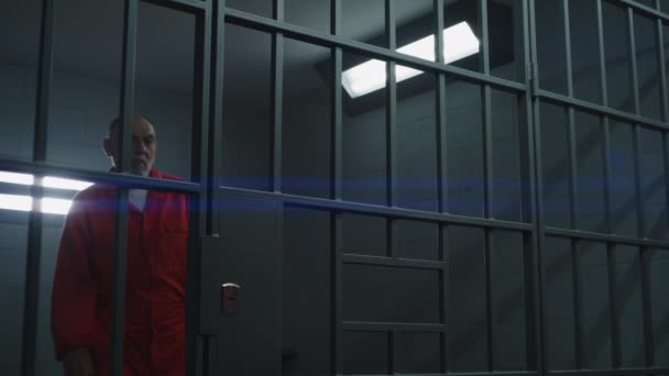 Elderly Criminal Orange Uniform Looks Barred Window Leans Bars Prison — Stock Video