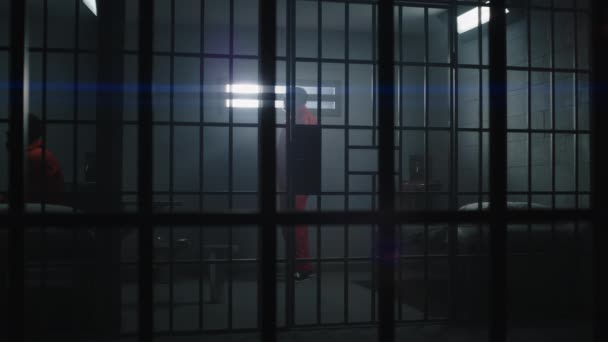 Turuncu Üniformalı Yaşlı Suçlu Parmaklıklı Pencereden Içeri Bakıyor Hapishane Hücresinde — Stok video