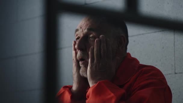 Den Äldre Brottslingen Orange Uniform Sitter Fängelsesäng Och Drömmer Frihet — Stockvideo