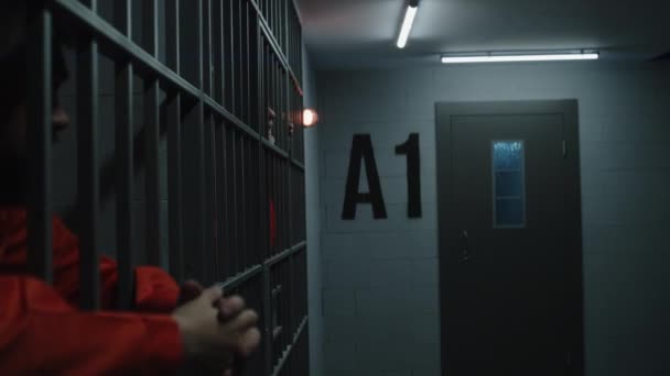 Vězni Oranžových Uniformách Opírají Kovové Mříže Naštvaný Starší Vězeň Gestikuluje — Stock video
