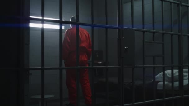Turuncu Üniformalı Yaşlı Suçlu Hapishane Hücresinde Yürüyor Parmaklıklı Pencereye Bakıyor — Stok video