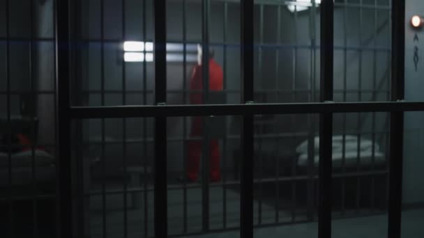 Criminel Âgé Uniforme Orange Lève Lit Prison Regarde Fenêtre Barrée — Video
