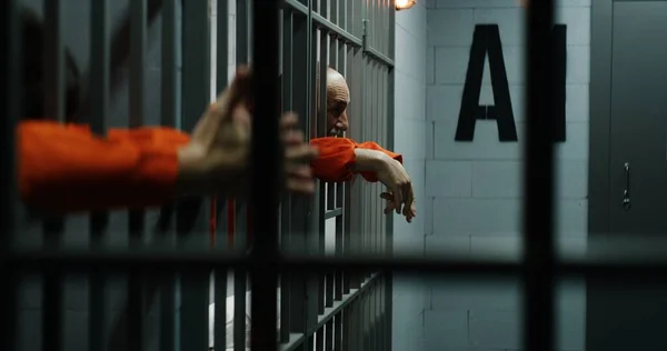 Häftlinge Orangefarbenen Uniformen Lehnen Gefängniszellen Metallstangen Schuldige Verbrecher Verbüßen Haftstrafen — Stockfoto