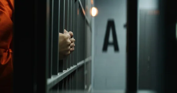 Großaufnahme Eines Gefangenen Orangefarbener Uniform Mit Metallstangen Der Der Gefängniszelle — Stockfoto