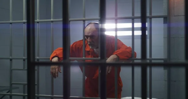 Starší Vězeň Oranžové Uniformě Drží Ruce Kovových Tyčích Dívá Kamery — Stock fotografie