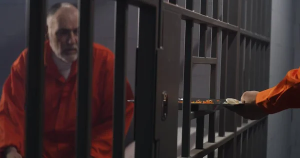 Starší Vězeň Oranžové Uniformě Sedí Vězeňské Cele Vězeňský Dozorce Dává — Stock fotografie