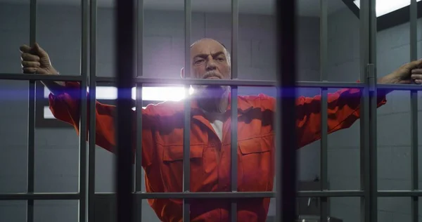 Ein Älterer Häftling Orangefarbener Uniform Hält Hände Metallstangen Verbrecher Verbüßt — Stockfoto