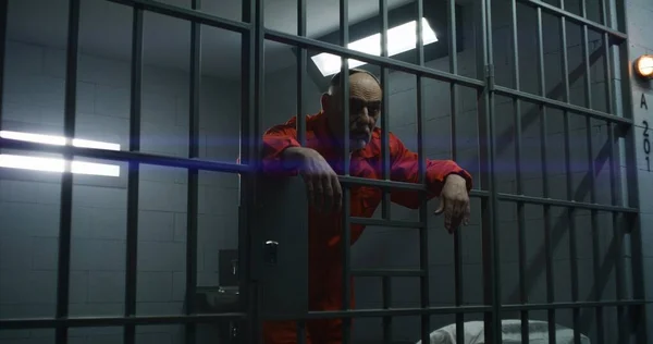 Ein Älterer Häftling Orangefarbener Uniform Lehnt Die Hände Metallstangen Verbrecher — Stockfoto