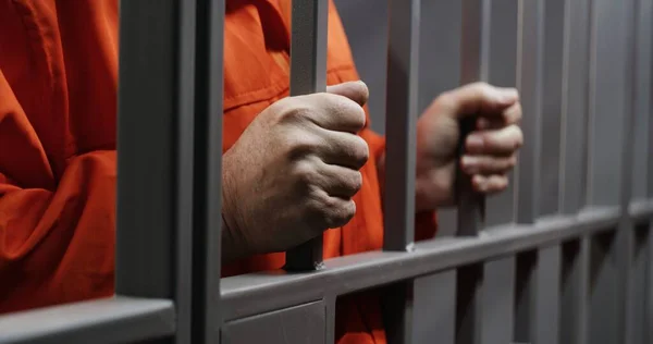 Hands Close Elderly Prisoner Orange Uniform Holding Metal Bars Standing — Stock Photo, Image