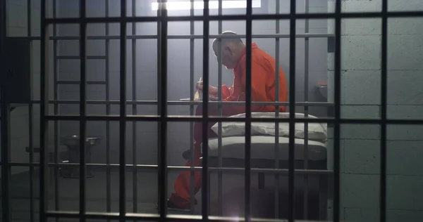 Oudere Gevangene Oranje Uniform Zit Cel Eet Voedsel Crimineel Zit — Stockfoto