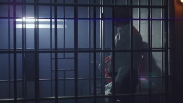 Vězeň Oranžové Uniformě Sedí Posteli Vězeňské Cele Žalářník Policejním Obuškem — Stock video