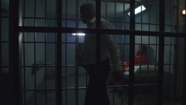 Gevangenisofficier Met Politiestokje Kijkt Naar Criminelen Gevangeniscellen Gevangenen Gevangenen Oranje — Stockvideo