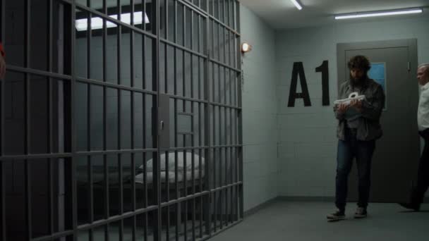 교도관은 범죄자를 감옥으로 우울증에 수감자들은 쇠창살에 머리를 숙인다 오렌지색 제복을 — 비디오