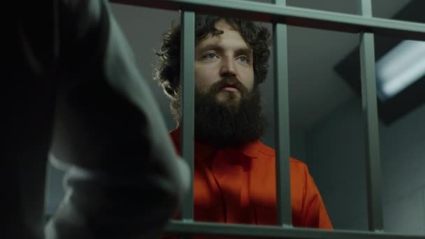 Więzień Daje Telefon Przestępcy Przez Metalowe Kraty Więzień Pomarańczowym Mundurze — Wideo stockowe
