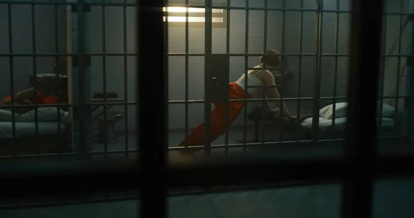 Jedna Žena Oranžové Uniformě Leží Posteli Druhá Vězeňské Cele Vězňkyně — Stock fotografie
