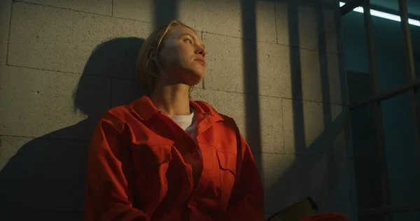 Turuncu Üniformalı Kadın Mahkum Hapishane Hücresinde Yatağında Oturup Ncil Okuyor — Stok fotoğraf