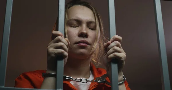 Female Prisoner Orange Uniform Holds Metal Bars Stands Jail Cell — Stock Photo, Image