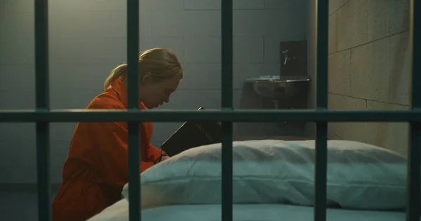 Female Prisoner Orange Uniform Kneels Bed Prays God Prison Cell — Stock Photo, Image