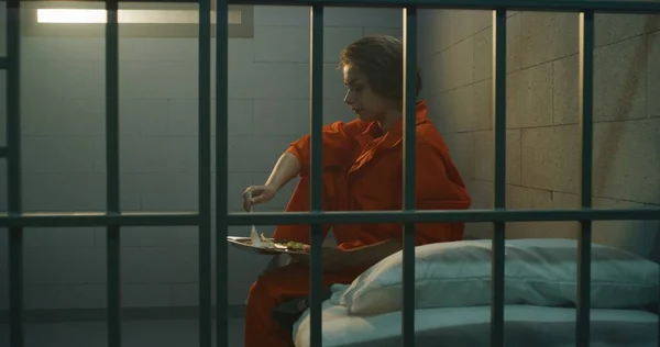 오렌지색 제복을 수감자들은 트롤리에서 교도소에 수감되어 범죄자에게 음식을 범죄자는 침대에 — 스톡 사진