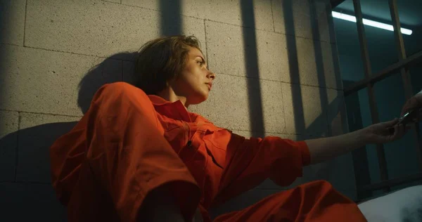 Žalářník Dává Telefon Vězeňkyni Žena Oranžové Uniformě Volá Sedí Posteli — Stock fotografie