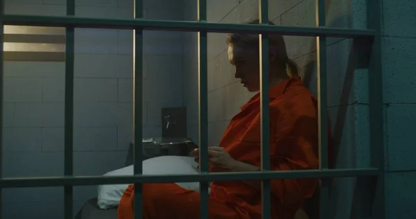 Więźniarka Używająca Smartfona Więzieniu Kobieta Pomarańczowym Mundurze Dzwoni Siedzi Więziennej — Zdjęcie stockowe