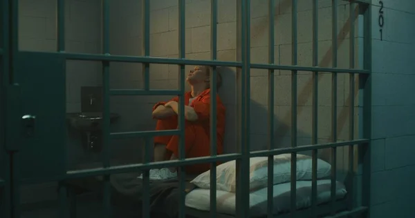 Női Rab Narancssárga Egyenruhában Ágyon Cellában Rácsos Ablakot Bámul Börtönbüntetést — Stock Fotó