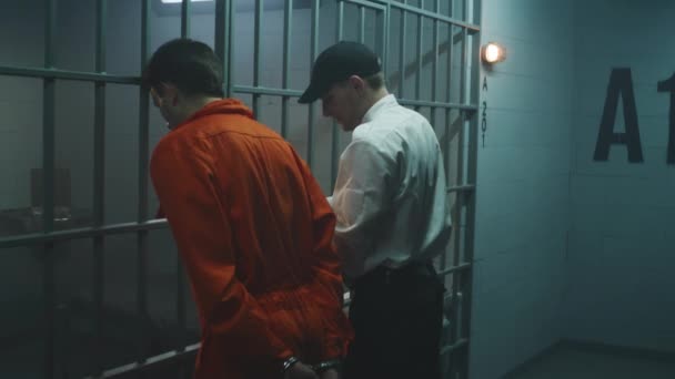 刑務所の警官が刑務所の監房を開設する オレンジ色の制服を着た男性は 監獄人と喧嘩する 犯罪者は刑務所や拘置所から脱出する 壮大なアクション映画のための戦闘シーン再生 フィルムプロデュース — ストック動画