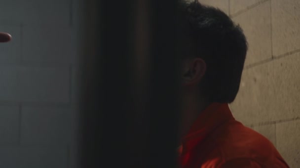 Prisoner Orange Uniform Sits Prison Cell Cellmate Speaks Aggressively Threatens — Stockvideo