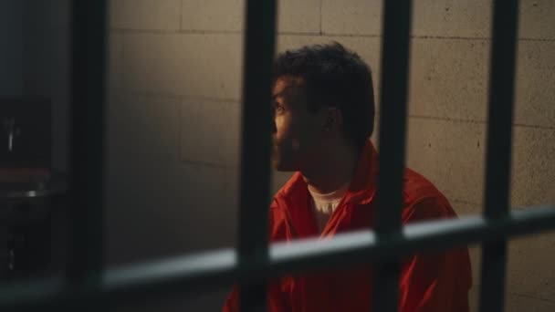 Prisioneiro Uniforme Laranja Fica Cela Prisão Criminoso Cela Fala Agressivamente — Vídeo de Stock