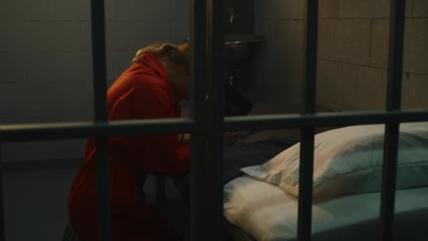 Kvinnlig Fånge Orange Uniform Knäböjer Nära Sängen Ber Till Gud — Stockvideo