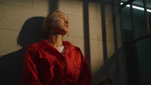 Depressive Häftlingsfrau Orangefarbener Uniform Sitzt Auf Dem Bett Der Gefängniszelle — Stockvideo