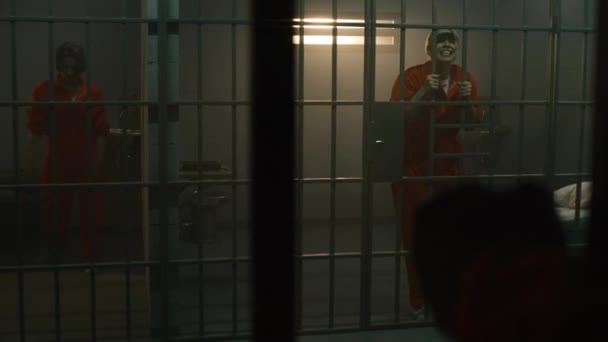Одна Агрессивная Заключенная Оранжевой Форме Кричит Заключенного Прыгает Решетку Другая — стоковое видео