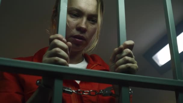 Γυναίκα Κρατούμενη Πορτοκαλί Στολή Στέκεται Στο Κελί Της Φυλακής Τρομαγμένη — Αρχείο Βίντεο
