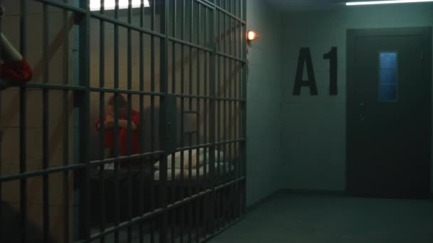 Una Prigioniera Uniforme Arancione Sta Dietro Sbarre Metallo Altra Siede — Video Stock