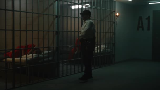 배턴을 교도소 장교는 오렌지색 유니폼을 포로들과 대화합니다 여성은 세포에 용어를 — 비디오