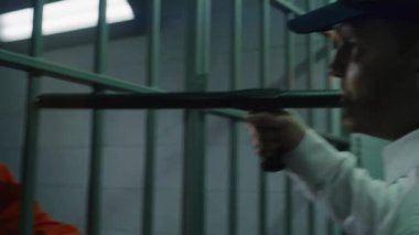Elinde copu olan gardiyan hapishane hücresinin önünde duruyor ve mahkumlara kabadayılık taslıyor. Depresyondaki Afrikalı Amerikalı adam tutukevinde hapis yatıyor. Cezaevinde turuncu üniformalı bir katil..