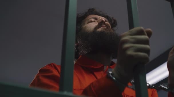 Muž Oranžové Uniformě Drží Kovové Mříže Spoutanýma Rukama Stojí Vězeňské — Stock video