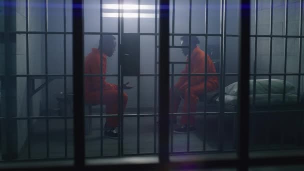 Los Prisioneros Afroamericanos Con Uniformes Naranjas Sientan Las Camas Cárcel — Vídeos de Stock