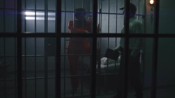 Fängelseofficeren Ger Bibeln Till Manlig Fånge Orange Uniform Fängelsecell Brottmål — Stockvideo