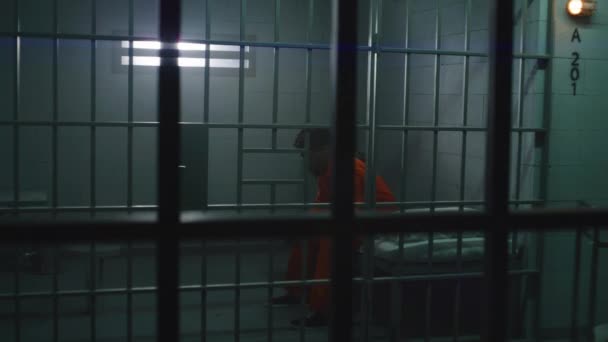 Człowiek Pomarańczowym Mundurze Daje Jedzenie Obsługi Wózka Więźnia Celi Przygnębiony — Wideo stockowe