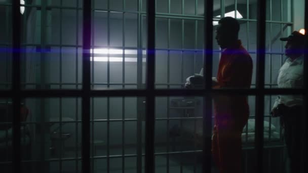ウォーデンは刑務所に新しい囚人を連れて来て 手錠を外した アフリカ系アメリカ人犯罪者は 矯正施設や拘置所で投獄期間を定めている 刑務所で有罪となった殺人犯 — ストック動画