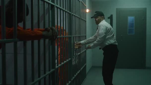 Wärter Legt Gefangenen Handschellen Und Führt Ihn Aus Der Gefängniszelle — Stockvideo
