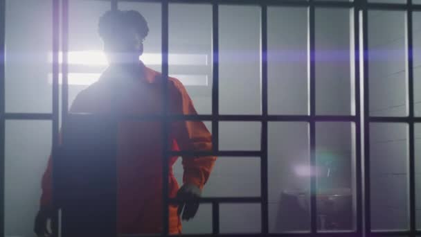 Ein Afroamerikanischer Häftling Orangefarbener Uniform Steht Vom Gefängnisbett Auf Und — Stockvideo