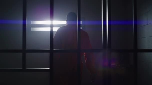 Przygnębiony Afroamerykanin Pomarańczowym Mundurze Wstaje Więziennego Łóżka Wchodzi Celi Patrzy — Wideo stockowe
