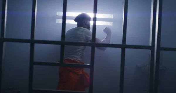 Manlig Afroamerikansk Fånge Orange Uniform Gör Skuggboxning Fängelsecell Fångvaktaren Går — Stockfoto