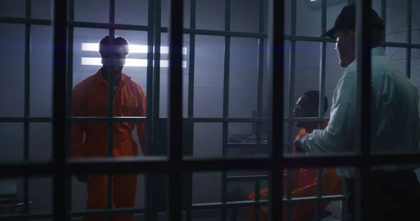刑務所の従業員は オレンジ色の制服で有罪判決を受け 彼を刑務所から連れ出した 囚人は刑務所 拘置所または矯正施設の犯罪のための投獄条件を提供する — ストック写真